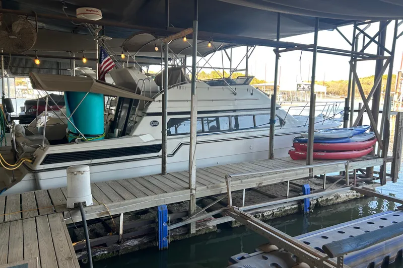 The Image of 1989 Carver 380 Santego yacht docked in a marina with kayaks nearby. - 1