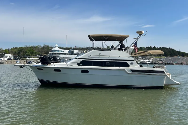 Slide: The Image of 1989 Carver 380 Santego yacht on calm water near marina buildings. - 25