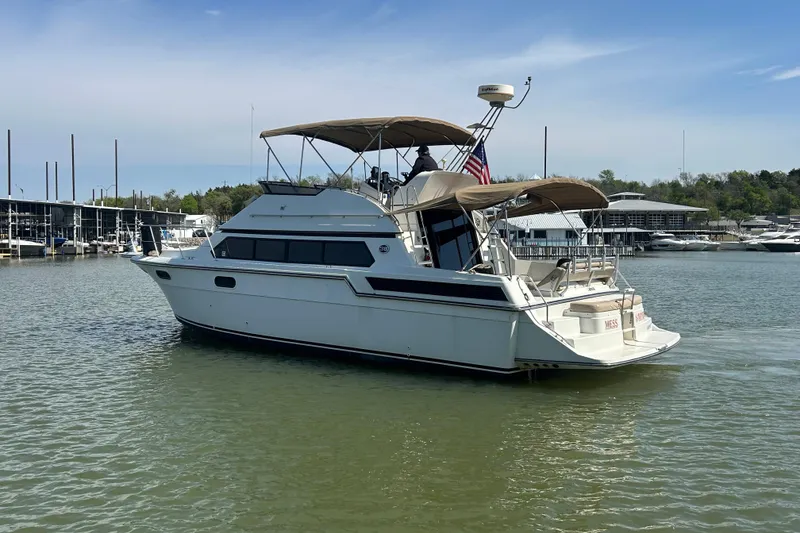 Slide: The Image of 1989 Carver 380 Santego yacht on calm water, featuring a spacious deck and canopy. - 27