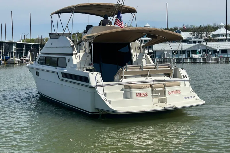Slide: The Image of 1989 Carver 380 Santego yacht on calm water near marina, under clear blue sky. - 28