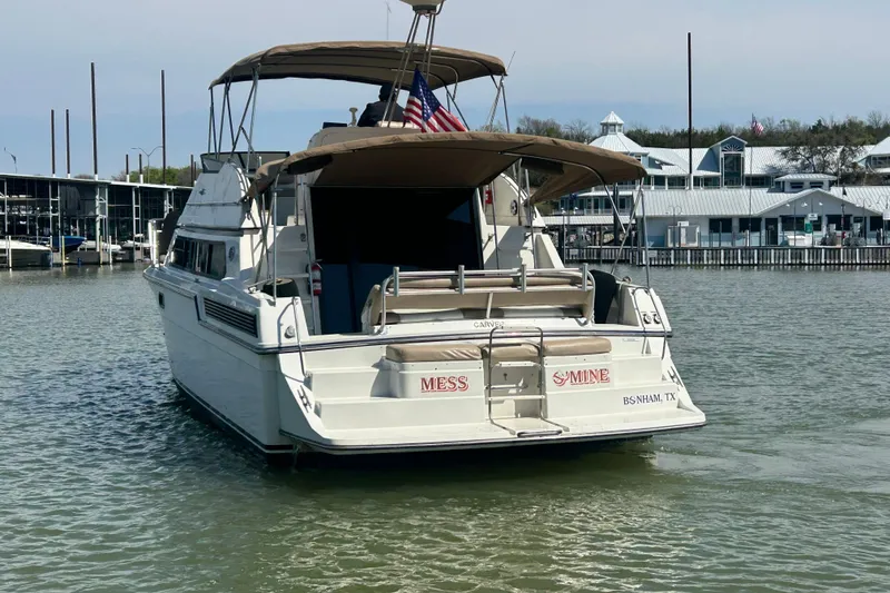Slide: The Image of 1989 Carver 380 Santego yacht docked in a marina, featuring a spacious deck and canopy. - 29