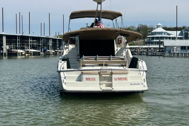 Slide: The Image of 1989 Carver 380 Santego yacht docked in a marina, displaying an American flag. - 30