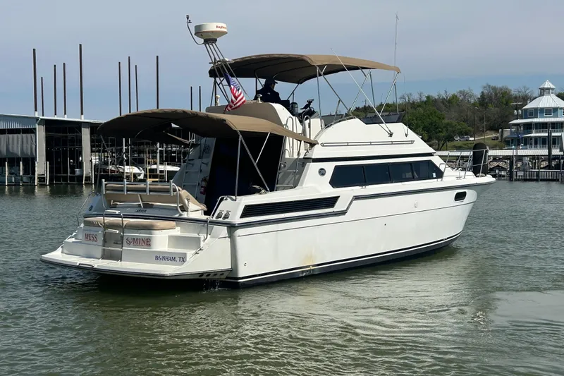 Slide: The Image of 1989 Carver 380 Santego yacht docked at marina, featuring spacious deck and canopy. - 32