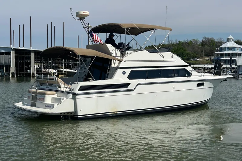 Slide: The Image of 1989 Carver 380 Santego yacht docked in a marina, featuring a sleek white design. - 33