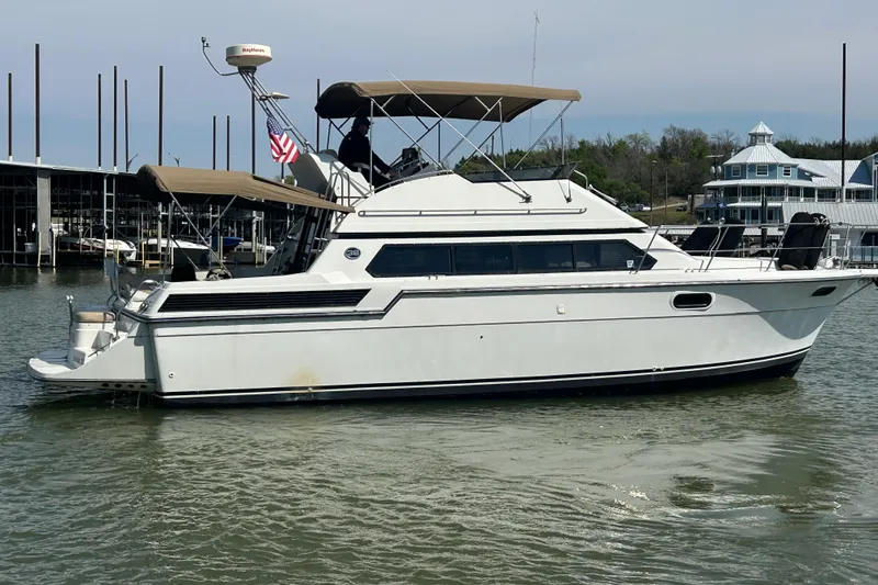 Slide: The Image of 1989 Carver 380 Santego yacht docked in a marina, featuring a sleek white design. - 34