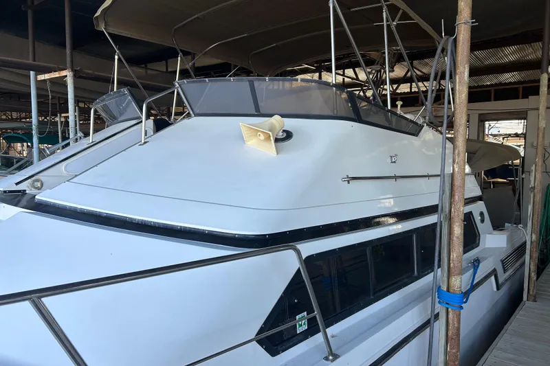 Slide: The Image of 1989 Carver 380 Santego yacht on a calm lake near a marina. - 4