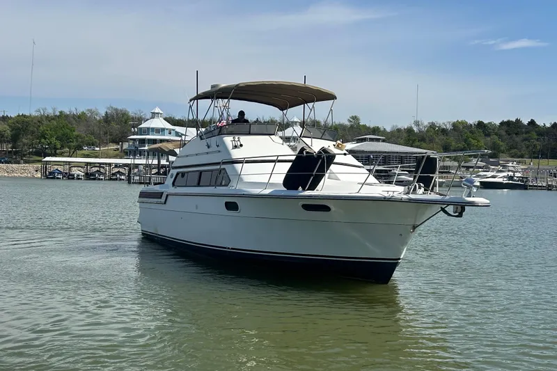 Slide: The Image of 1989 Carver 380 Santego yacht cruising on a calm lake near a marina. - 40