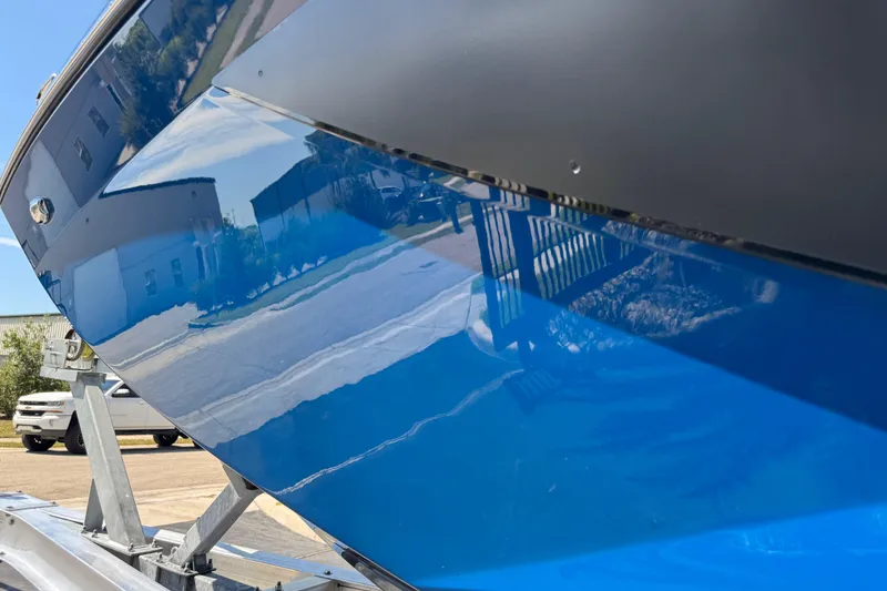 Slide: The Image of 2022 Scarab 285 ID boat with sleek blue hull on a trailer. - 100