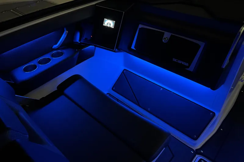 Slide: The Image of 2022 Scarab 285 ID boat interior with blue LED lighting and cup holders. - 105