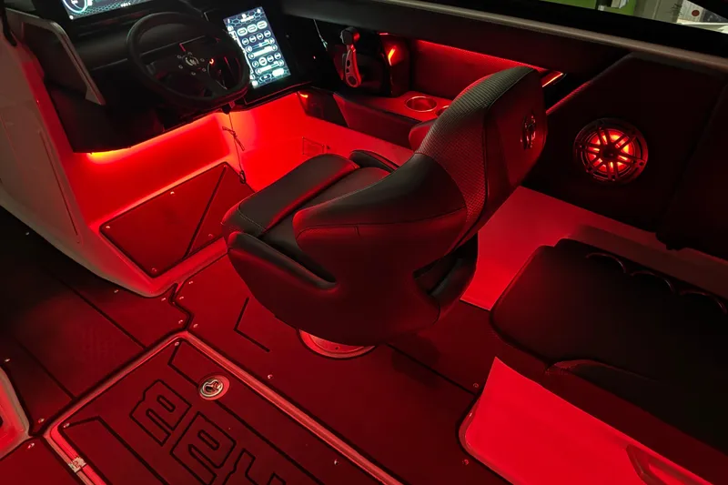 Slide: The Image of 2022 Scarab 285 ID boat interior with red LED lighting and modern dashboard. - 128
