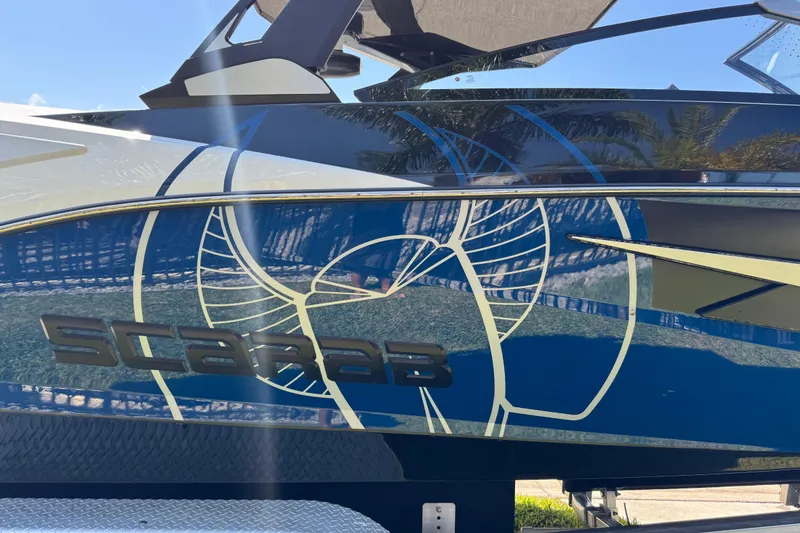 Slide: The Image of 2022 Scarab 285 ID boat with sleek blue and white design, featuring bold graphics. - 13