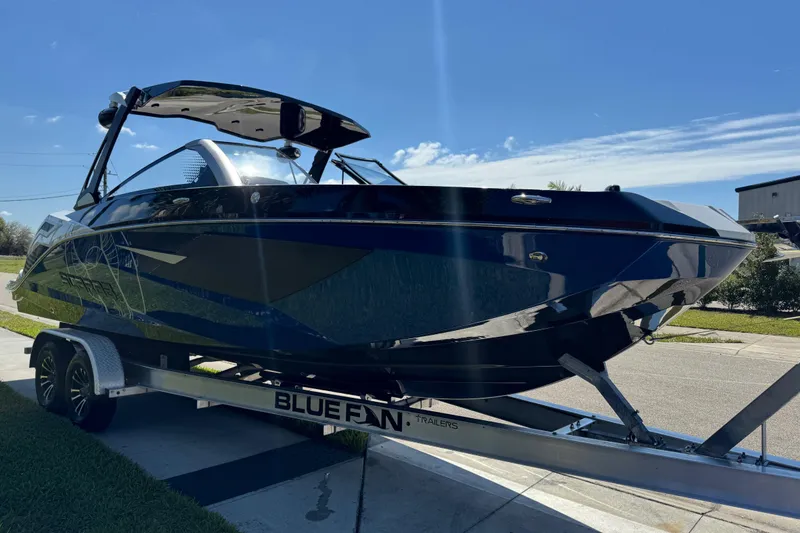Slide: The Image of 2022 Scarab 285 ID boat on Bluefin trailer under clear blue sky. - 14