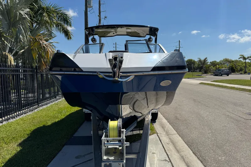Slide: The Image of 2022 Scarab 285 ID boat on trailer, parked on a sunny street. - 18
