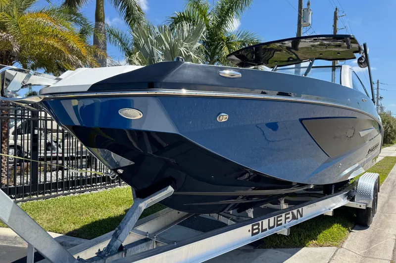 Slide: The Image of 2022 Scarab 285 ID boat on trailer, parked outdoors with palm trees. - 19