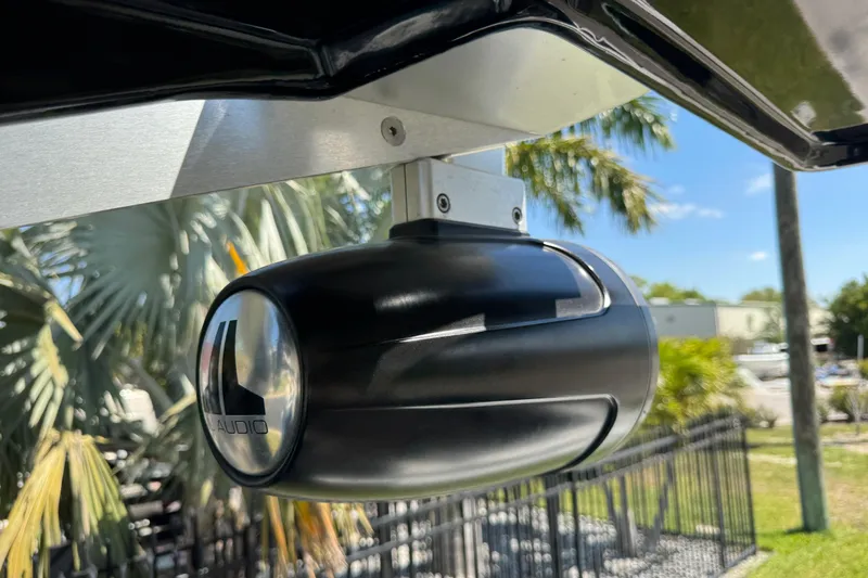 Slide: The Image of Close-up of JL Audio speaker on 2022 Scarab 285 ID boat, with palm trees in background. - 37