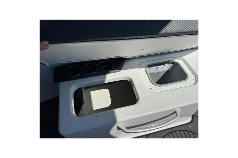 Slide: The Image of 2022 Scarab 285 ID boat storage compartments with cup holders and open lids. - 43