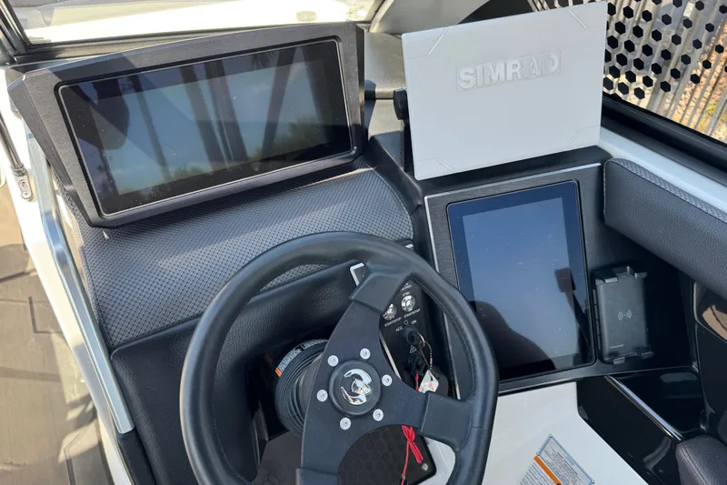 Slide: The Image of 2022 Scarab 285 ID boat dashboard with Simrad navigation system and steering wheel. - 45