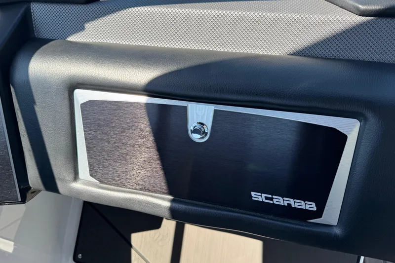 Slide: The Image of 2022 Scarab 285 ID dashboard compartment with sleek black and silver design. - 47