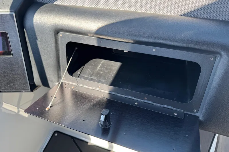 Slide: The Image of Open storage compartment in 2022 Scarab 285 ID boat dashboard. - 48