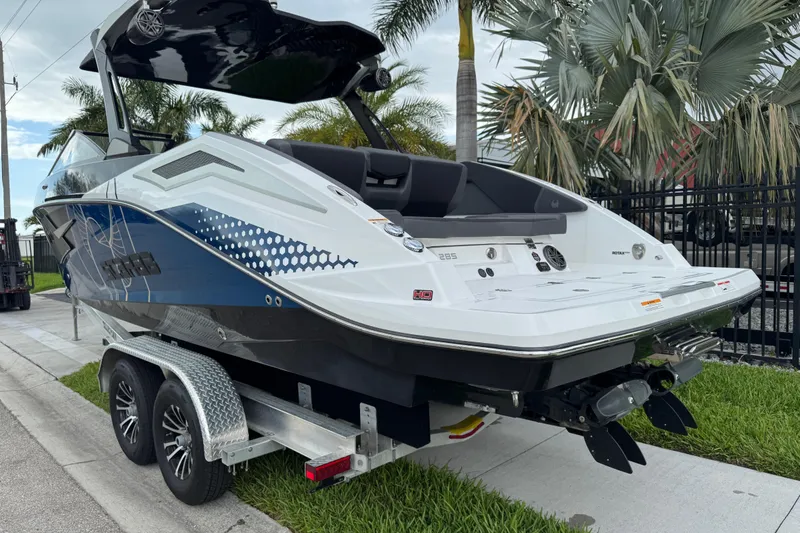 Slide: The Image of 2022 Scarab 285 ID boat on trailer, sleek design, parked near palm trees. - 5