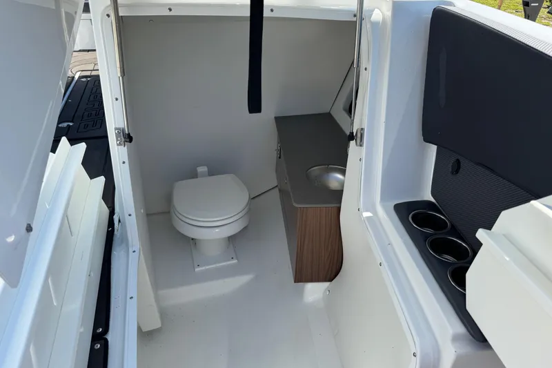 Slide: The Image of 2022 Scarab 285 ID boat interior with toilet, sink, and cup holders. - 52