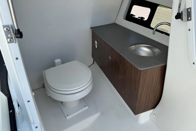 Slide: The Image of 2022 Scarab 285 ID boat bathroom with toilet, sink, and wooden cabinetry. - 53