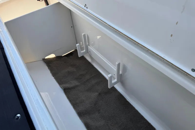 Slide: The Image of Storage compartment in a 2022 Scarab 285 ID boat, featuring hooks and carpet lining. - 59