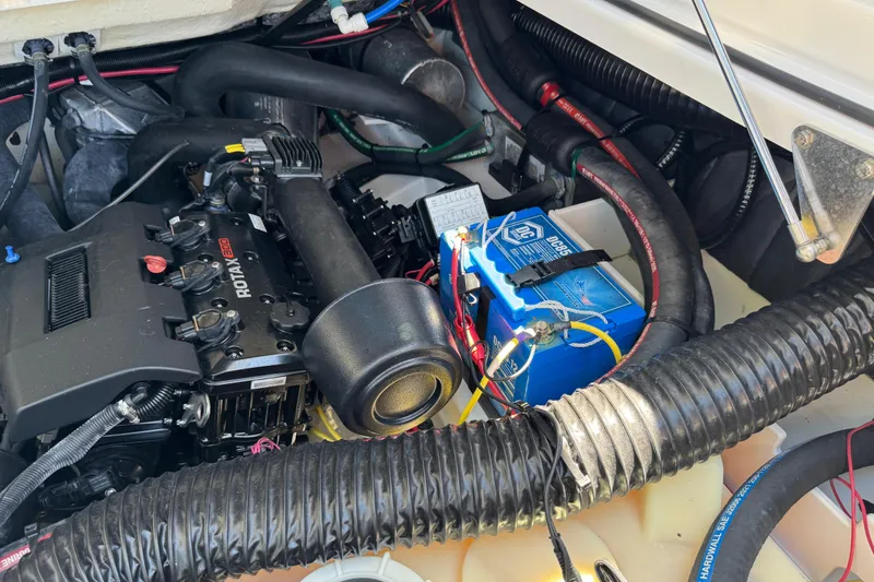 Slide: The Image of Engine compartment of a 2022 Scarab 285 ID boat with visible battery and wiring. - 63