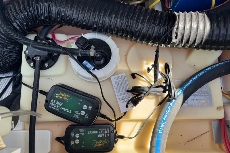 Slide: The Image of Battery chargers and wiring inside a 2022 Scarab 285 ID boat engine compartment. - 65