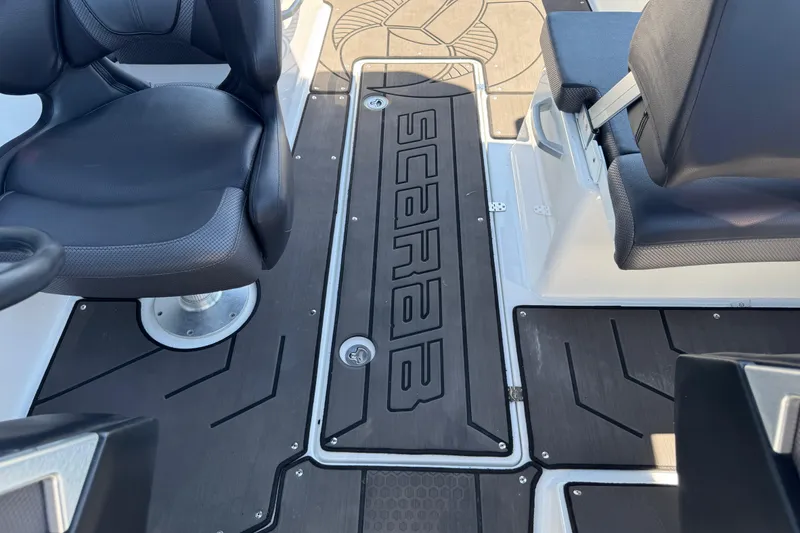 Slide: The Image of 2022 Scarab 285 ID boat interior with black seating and branded flooring. - 88