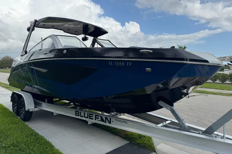 Slide: The Image of 2022 Scarab 285 ID boat on Bluefin trailer, parked on a street. - 9