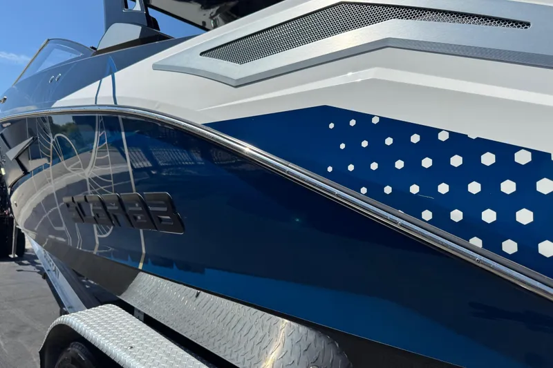 Slide: The Image of 2022 Scarab 285 ID boat with sleek blue and white design on trailer. - 97