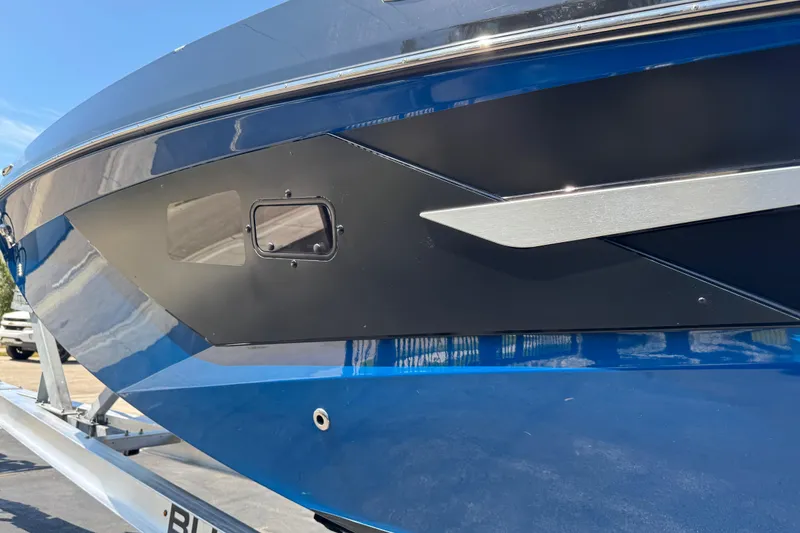 Slide: The Image of 2022 Scarab 285 ID boat, sleek blue and black hull design, close-up view. - 99