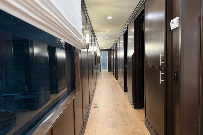 Slide: The Image of Luxurious interior hallway of a 2019 Sumerset Houseboat, featuring sleek wood paneling and modern lighting. - 15