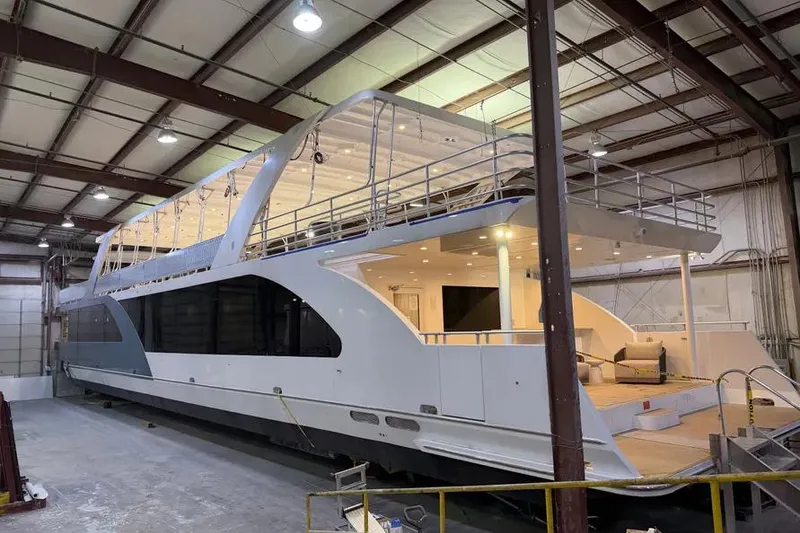 Slide: The Image of 2019 Sumerset Houseboat 20' x 100' in warehouse, showcasing modern design and spacious deck. - 23