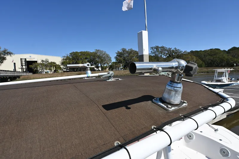 Slide: The Image of 2017 Tidewater 210 LXF boat with rod holders, docked under clear blue sky. - 14