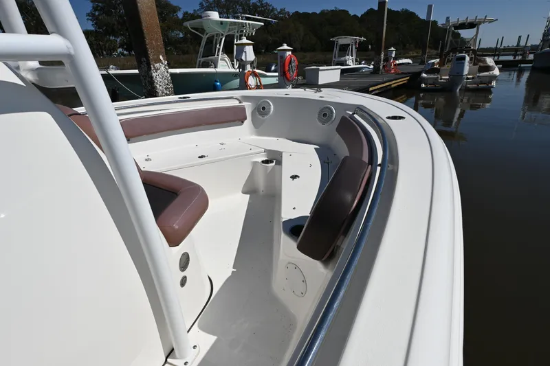 Slide: The Image of 2017 Tidewater 210 LXF boat with cushioned seating, docked at a marina. - 6