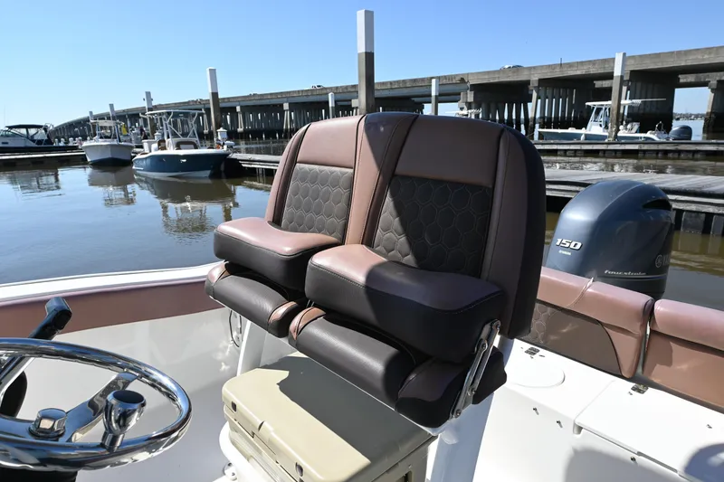 Slide: The Image of 2017 Tidewater 210 LXF boat interior with dual seats and Yamaha engine at marina. - 7