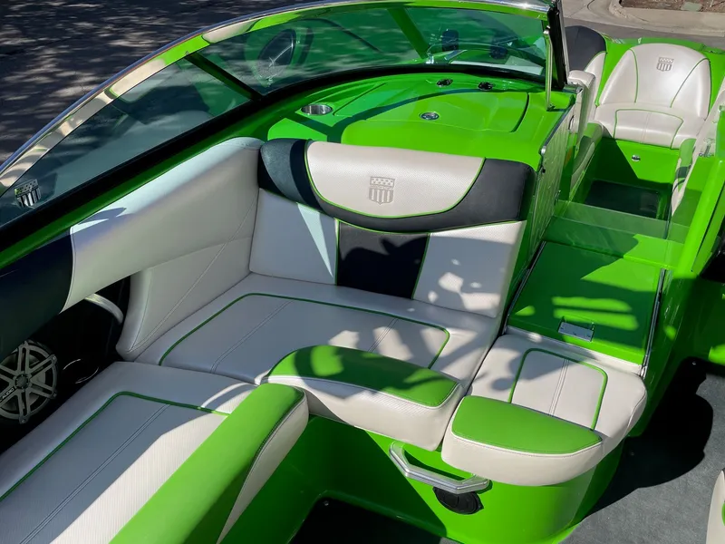 Slide: The Image of Interior of a green 2013 MasterCraft XStar boat with white seating. - 10