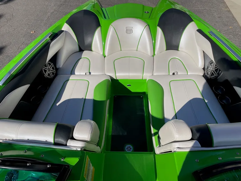 Slide: The Image of Interior of a 2013 MasterCraft XStar boat with green and white seating. - 11