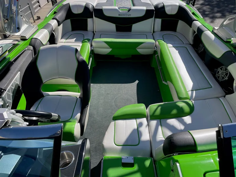 Slide: The Image of Interior of a 2013 MasterCraft XStar boat with green and white seating. - 12