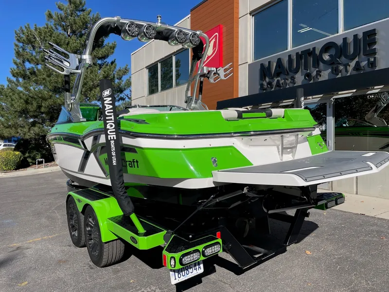 Slide: The Image of Green 2013 MasterCraft XStar boat outside Nautique dealership. - 3