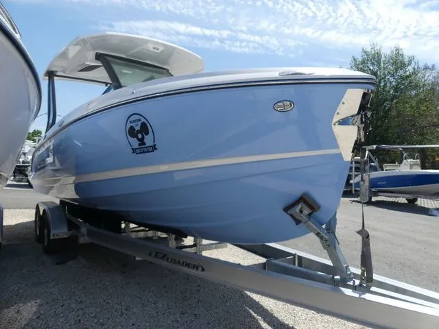 The Image of 2026 Monterey Elite 25 OB boat on trailer, blue hull. - 1