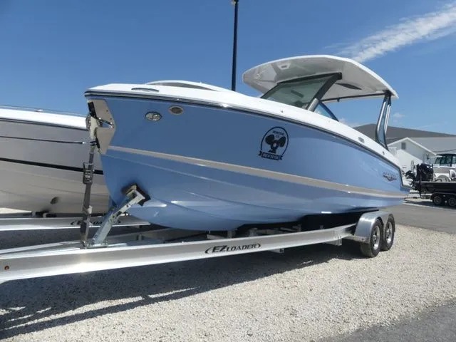 Slide: The Image of 2026 Monterey Elite 25 OB boat on trailer, light blue. - 2