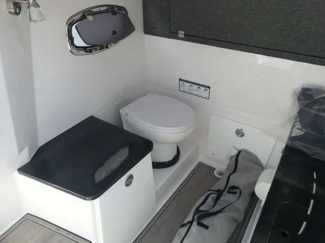 Slide: The Image of Interior of 2026 Monterey Elite 25 OB with toilet and storage. - 21