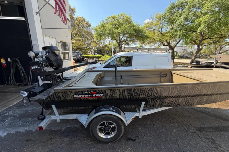Slide: The Image of 2026 Gator Tail 1754 Extreme boat on trailer, parked outdoors near a white van. - 2