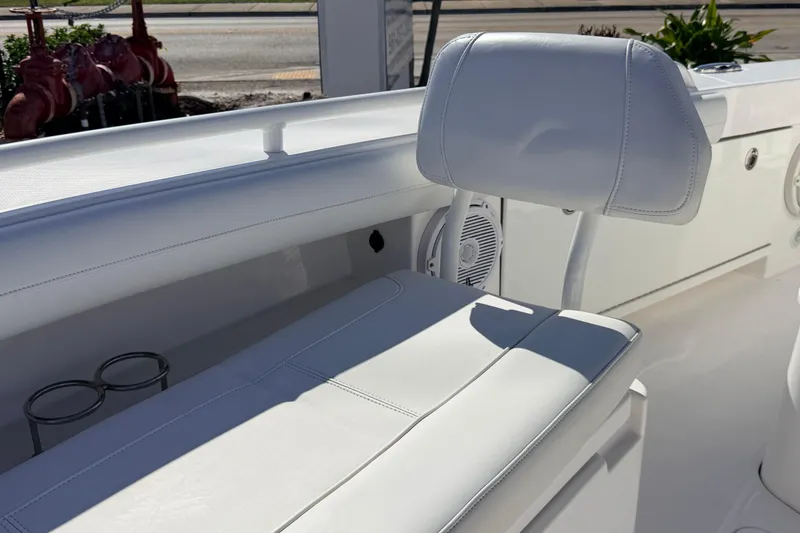 Slide: The Image of White seating on 2019 Everglades 253 Center Console boat, featuring cup holders and speaker. - 21