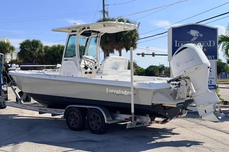 Slide: The Image of 2019 Everglades 253 Center Console boat on trailer, parked outdoors near palm trees. - 4