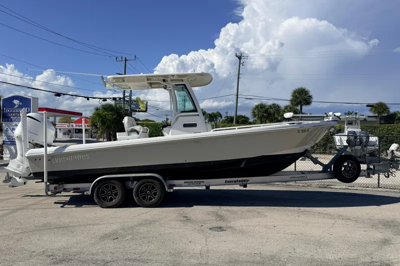 Slide: The Image of 2019 Everglades 253 Center Console boat on trailer, parked outdoors under blue sky. - 7