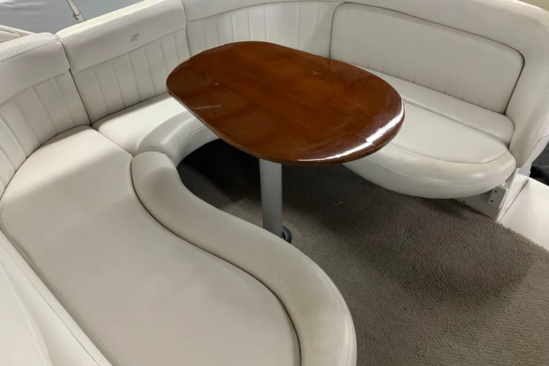 Slide: The Image of 2003 Four Winns 248 Vista boat interior with white seating and wooden table. - 10